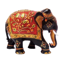 Wooden hand painted elephant figurine with red floral saddle and gold details.