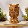Handcrafted wooden owl statue a jalee work on it and two small owl also setting under it