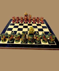 Wooden chess set on a chess board, Maharajah style chess in green and red color theme