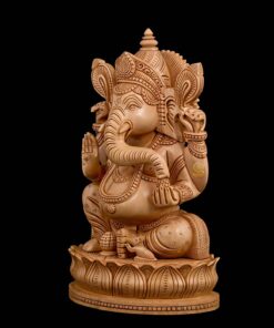 Wooden Ganesha statue with carved lotus pedestal and black background.