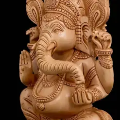 Intricately carved wooden Ganesha statue with ornate crown and blessing gesture.