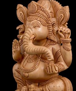 Intricately carved wooden Ganesha statue with ornate crown and blessing gesture.