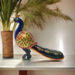 Colorful ceramic peacock sculpture with intricate floral patterns and a vibrant tail.