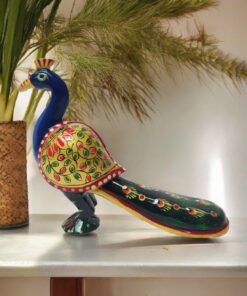 Colorful ceramic peacock sculpture with intricate floral patterns and a vibrant tail.