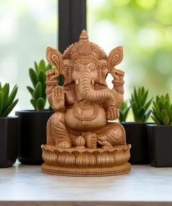 Beautiful wooden Lord Ganesha statue with symbolic arms, facing a natural, serene setting.
