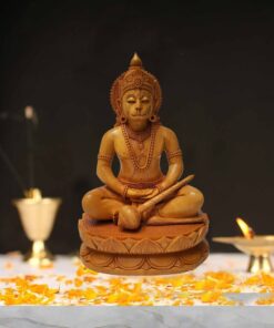 Wooden Hindu deity figurine with marigold petals, traditional ornaments, and sacred ritual setting.