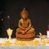 Wooden Hindu deity figurine with marigold petals, traditional ornaments, and sacred ritual setting.