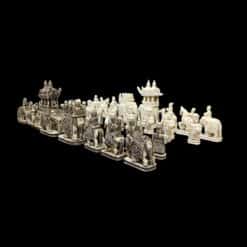 Ivory chess set with detailed, mythological figures and architectural structures on a black background.