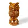 Hand-carved wooden owl sculpture with intricate feather details and woodland foliage base for home decor.