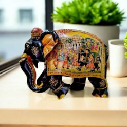 Colorful traditional Indian decorative elephant figurine with intricate floral patterns and festive procession scene.