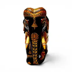 Carved wooden elephant figurine with ornate gold and red painted details.