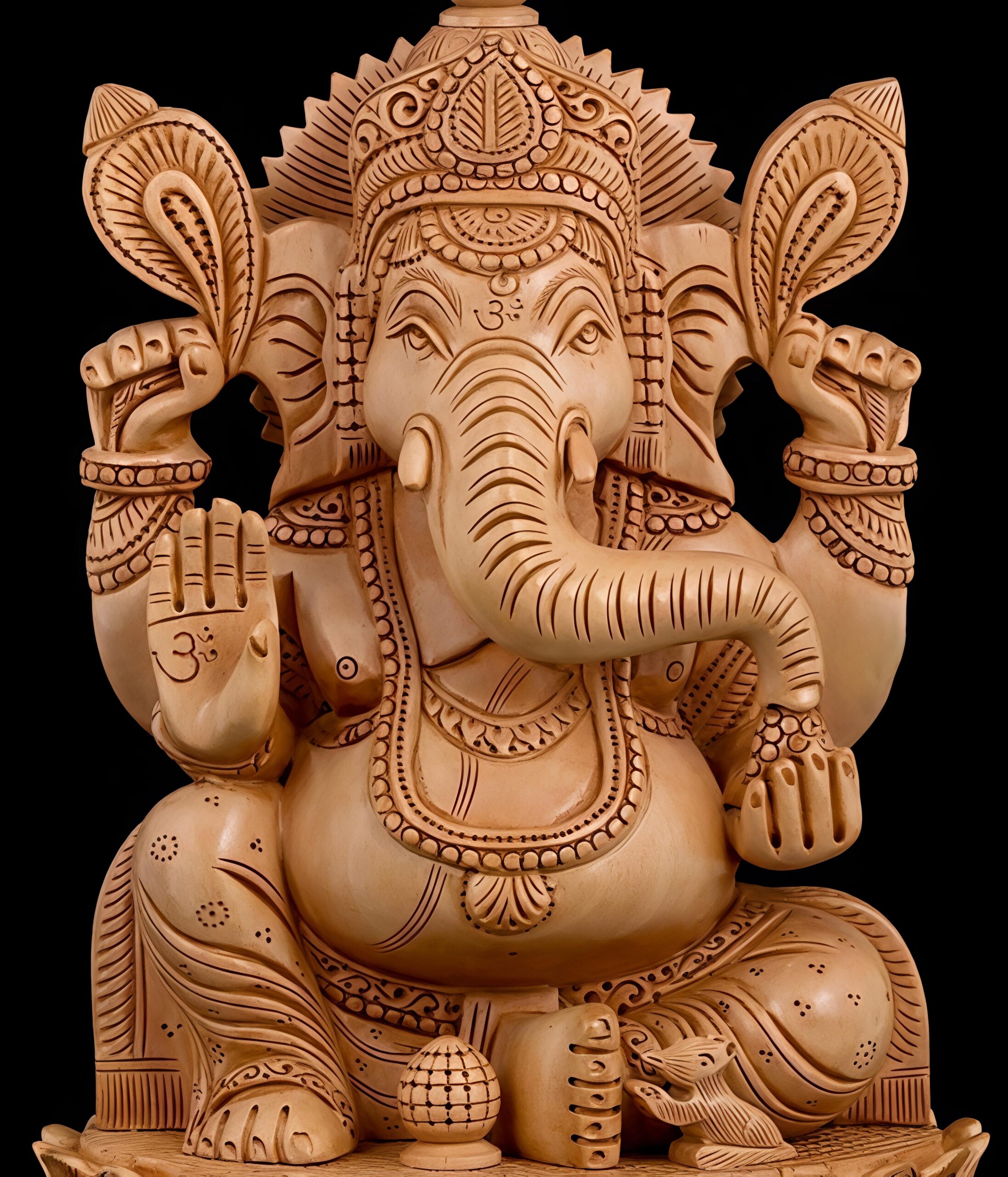 Wooden Ganesha statue with intricate carvings and Om symbols.