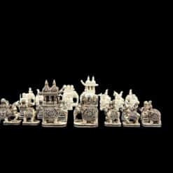 Intricate handcrafted camel bone chess set featuring cultural warriors, elephants, and palace structures