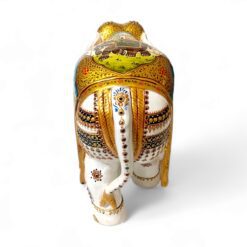 Decorative ceramic elephant sculpture with detailed village scene, gold accents.