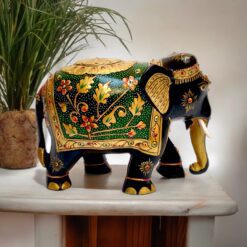 Colorful handcrafted elephant figurine with gold accents, floral patterns, and intricate detailing.