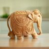 Handcrafted wooden elephant sculpture with intricate carvings, showcasing traditional artistry.