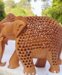 Intricately carved wooden elephant sculpture with detailed patterns, tusks, and natural wood finish.