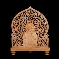 Wooden Ganesha statue backdrop with ornate carved floral arch and shrine panel.