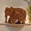 Hand-carved clay elephant sculpture with intricate patterns and wildlife motifs, showcasing traditional craftsmanship.