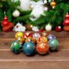 Paper Mache hand painted baubles with Christmas tree in back ground