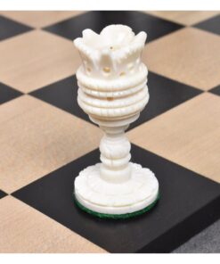 Ornate bone chess rook with flower-shaped top on classic wooden chessboard.