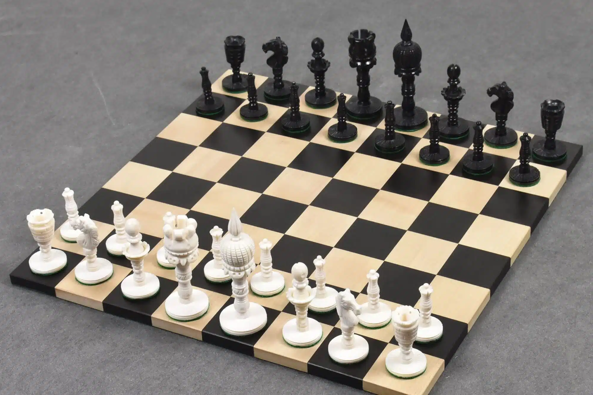 Elegant carved black and white chess set on a classic board for strategic gameplay.