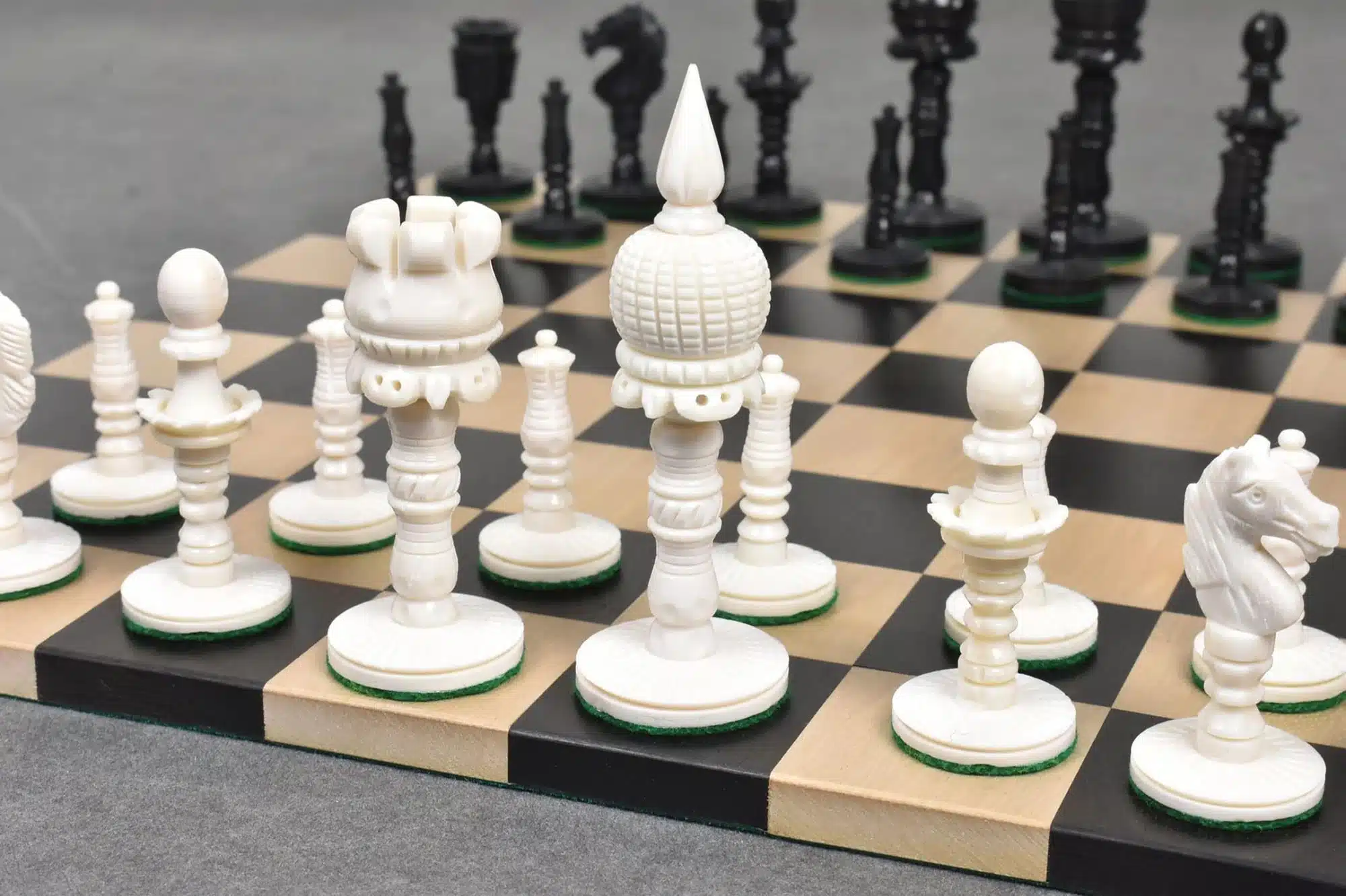 Beautiful handcrafted white and black chess set on a classic chessboard for strategy and craftsmanship.