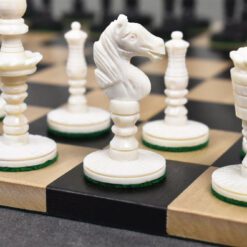Elegant camel bone chess set with detailed white and black chess pieces on a crafted checkered board.