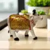 Handcrafted painted cow figurine with gold, red, and green floral motifs for prosperity and decor.