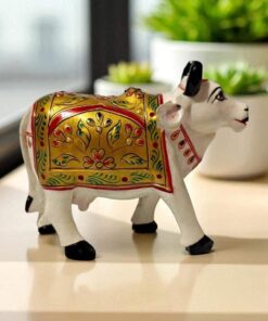 Handcrafted painted cow figurine with gold, red, and green floral motifs for prosperity and decor.