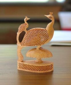 Intricate wooden peacock sculpture with a baby peacock and honeycomb-patterned feathers.