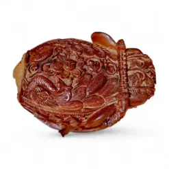 Intricate reddish-brown carved wooden ornament with floral relief and figurative details.