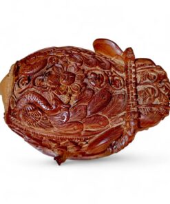 Intricate reddish-brown carved wooden ornament with floral relief and figurative details.