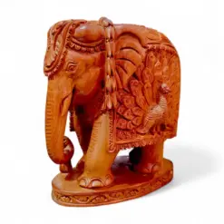 Hand-carved sandalwood elephant statue with peacock design and ornate ceremonial details.