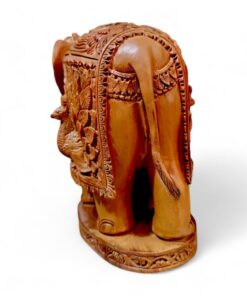 Ornate carved wooden elephant figurine with ceremonial saddle on decorative base.