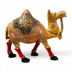 Ornate golden camel figurine with colorful Indian saddle and red legs.
