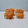 Decorative wooden elephant figurines with carved floral patterns on gray tabletop.