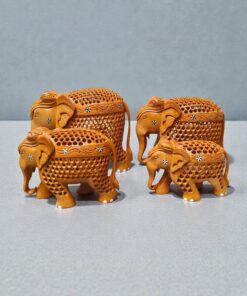 Decorative wooden elephant figurines with carved floral patterns on gray tabletop.