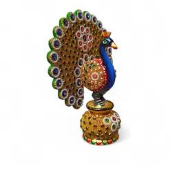 Ornate jeweled peacock figurine with gold fan tail on decorative pedestal.