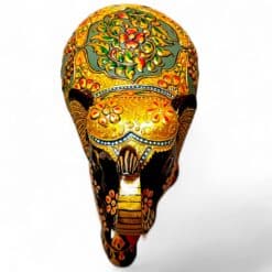 Ornate painted elephant mask with gold floral Indian folk art design.