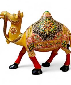 Ornate golden camel figurine with colorful Indian saddle and red legs.