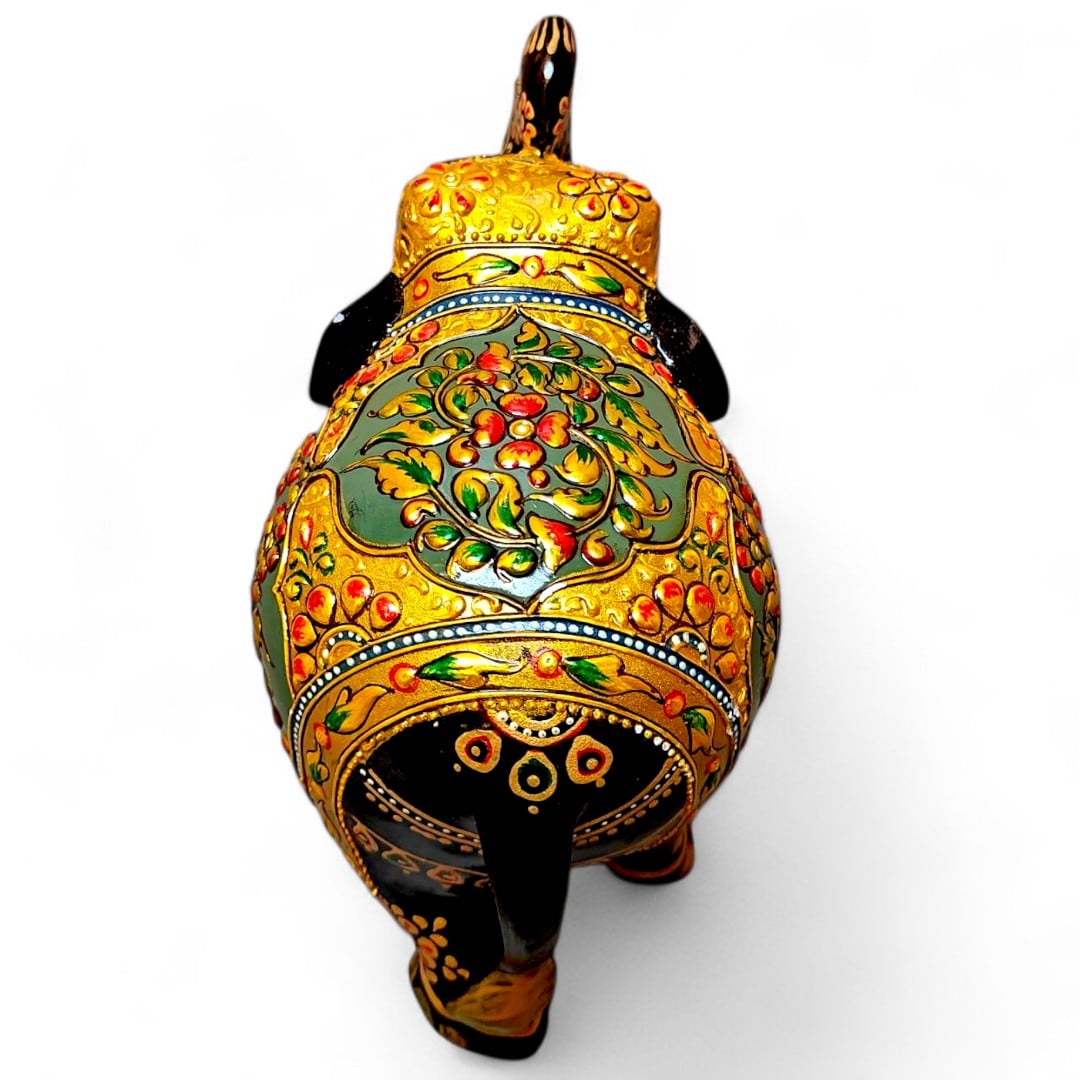Ornate hand-painted elephant figurine with gold floral patterns and raised trunk.