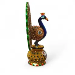 Ornate jeweled peacock figurine with green tail on decorative gold pedestal.