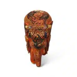 Ornate painted elephant figurine with gold floral saddle on white background.