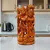 Handcrafted Radha Krishna wooden statue on  countertop with flute and ornate carvings.
