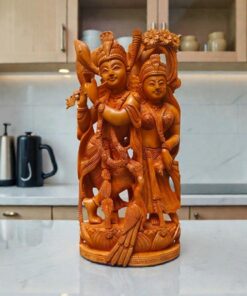 Handcrafted Radha Krishna wooden statue on  countertop with flute and ornate carvings.