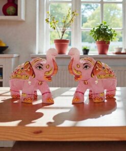 Rose Quartz elephant figurines on sunlit wooden table with plants by window.