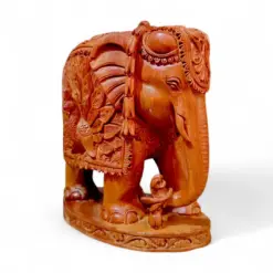 Hand-carved wooden elephant figurine with ornate ceremonial saddle and peacock design.