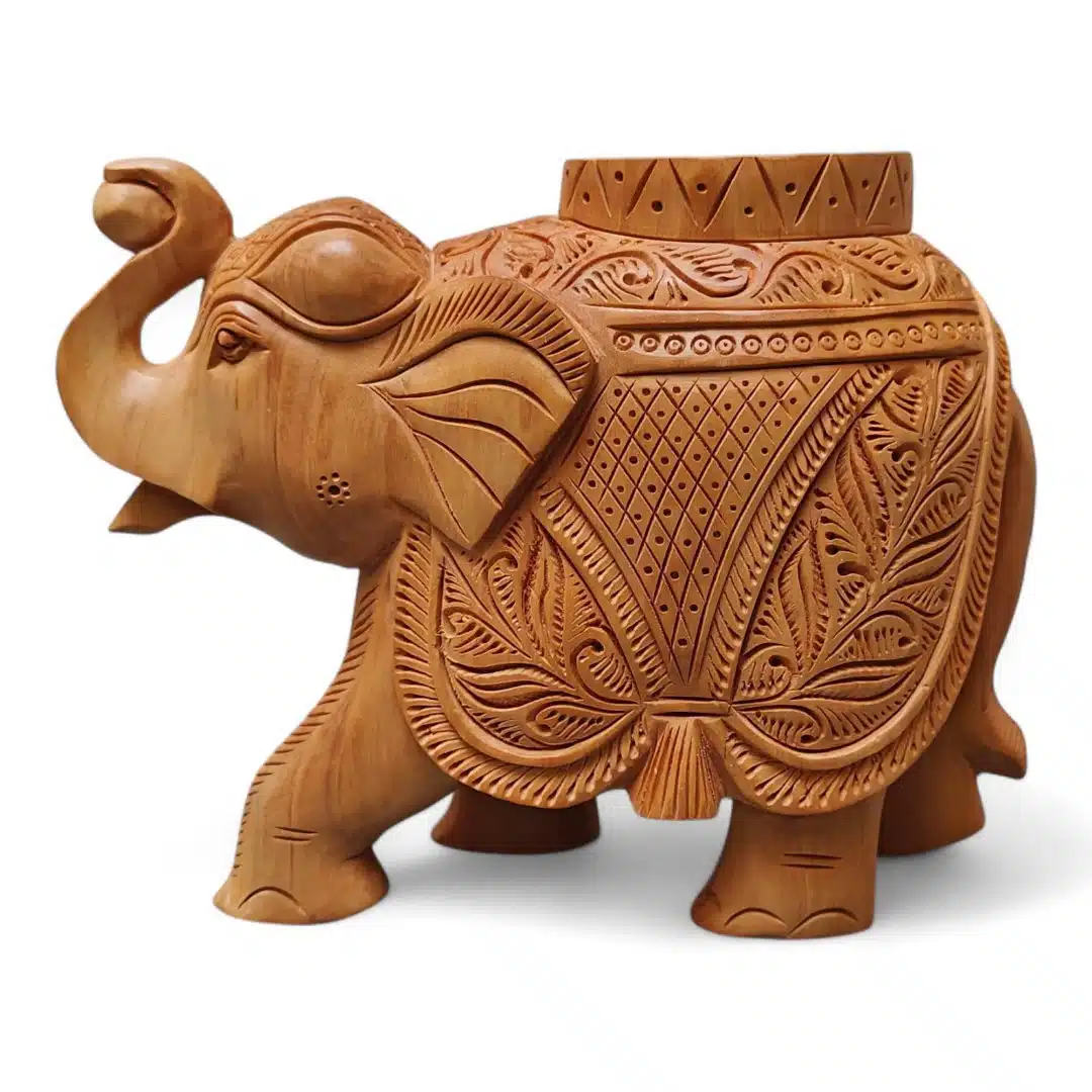 Hand-carved wooden elephant sculpture with raised trunk and ornate floral saddle decor.