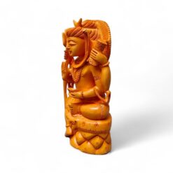 Hand-carved amber deity figurine seated on ornate pedestal.
